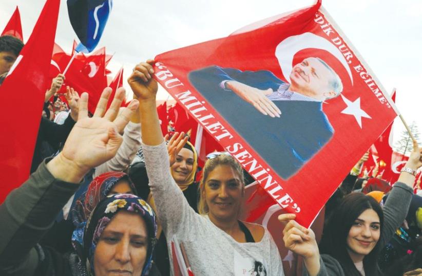 SUPPORTERS OF Turkish President Tayyip Erdogan wave national flags as they wait for his arrival at the Presidential Palace in Ankara. (photo credit: REUTERS)