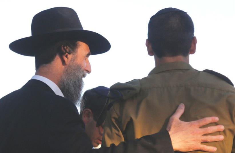 A haredi man embraces a youth from the Orthodox community who has joined the army (photo credit: MARC ISRAEL SELLEM)