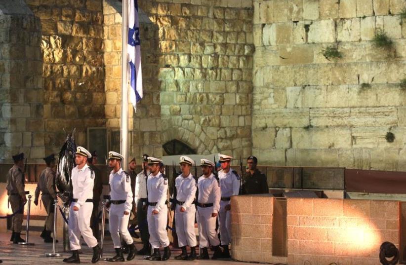 Soldiers rake down the flag ahead of Memorial Day ceremony at the Western Wall  (photo credit: MARC ISRAEL SELLEM/THE JERUSALEM POST)