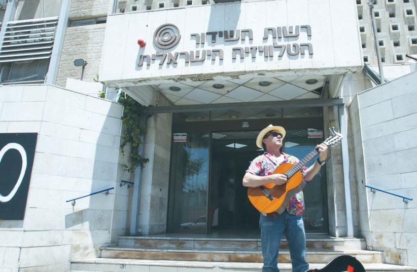 ARIEH O’SULLIVAN, ‘IBA English News’ anchor, plays the blues as the Israel Broadcasting Authority is shut down, in front of the IBA building in the capital’s Romema neighborhood (photo credit: MARC ISRAEL SELLEM/THE JERUSALEM POST)