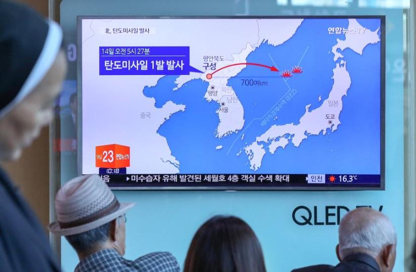 People watch a news report on North Korea firing a ballistic missile, at a railway station in Seoul, South Korea, May 14, 2017 (photo credit: REUTERS)