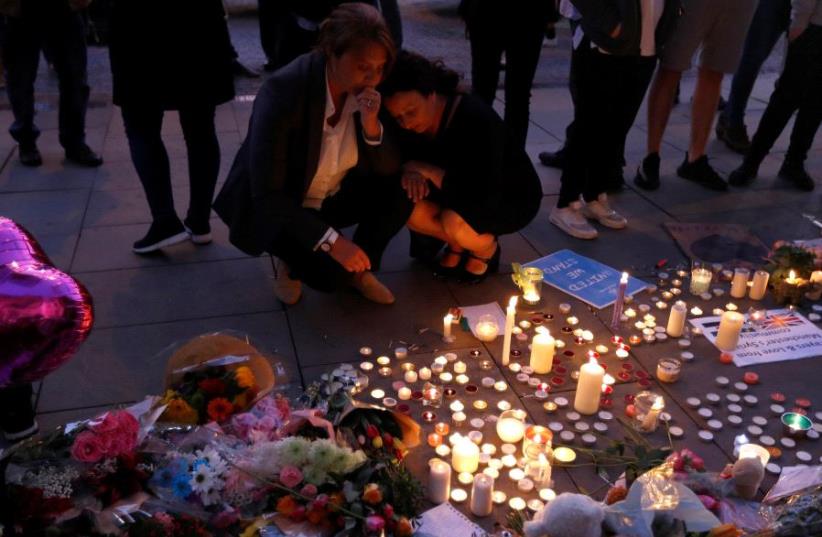 People pay their respects to the victims of the deadly suicide bombing in Manchester that took place during an Ariana Grande concert.  (photo credit: REUTERS)