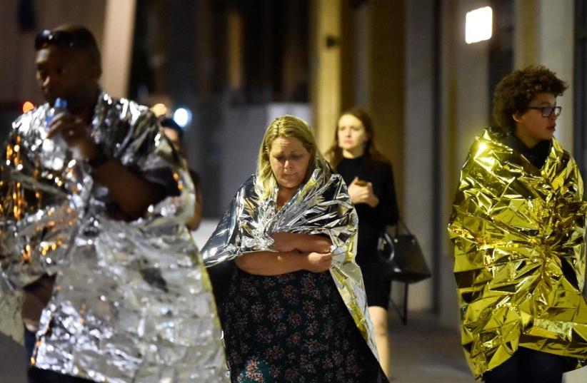 People flee as police attend to an incident near London Bridge in London (photo credit: REUTERS / HANNAH MCKAY)