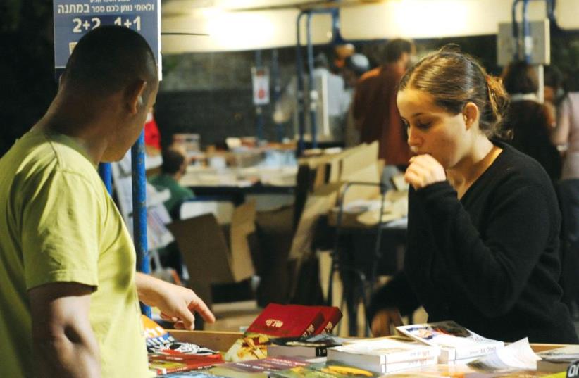 People purchase books at the annual book fair in Jerusalem (photo credit: AMOS BEN-GERSHOM/GPO)