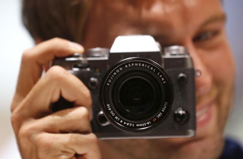 A model poses with a camera (photo credit: REUTERS/INA FASSBENDER)