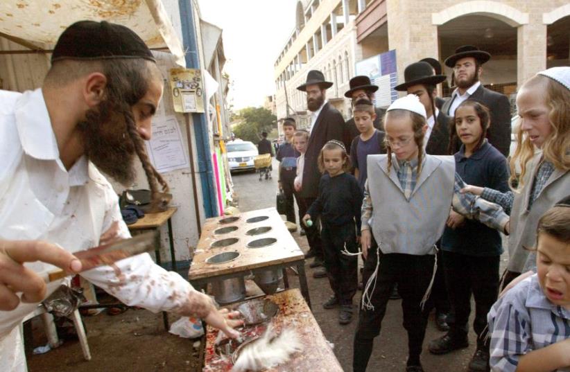 DATE IMPORTED: October 07, 2003 Group of ultra-Orthodox Jews watch a butcher put drain the blood from a slaughtered chickens in the Mea Shearim neighbourhood in Jerusalem October 2 2003 (photo credit: REUTERS/GIL COHEN MAGEN)