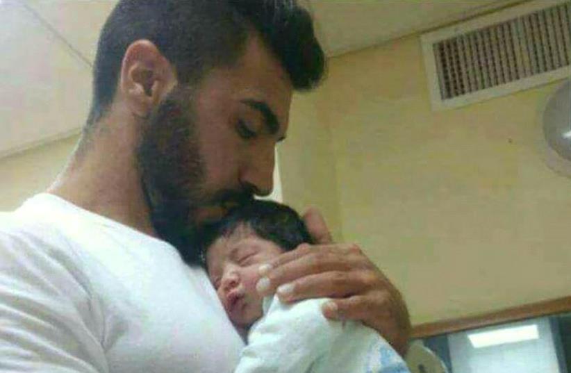 Slain police officer Hail Stawi and child (photo credit: ISRAEL POLICE)