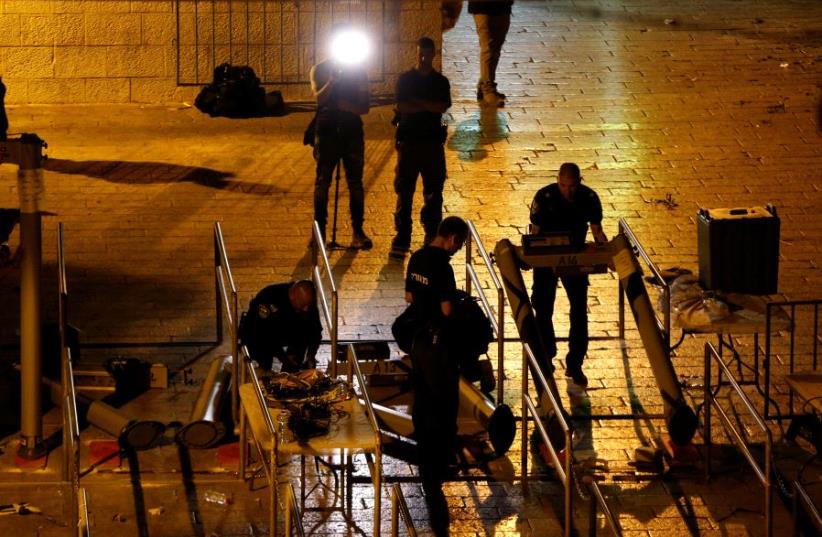 Israeli security forces remove metal detectors which were recently installed at an entrance to the Temple Mount (photo credit: AMMAR AWAD / REUTERS)