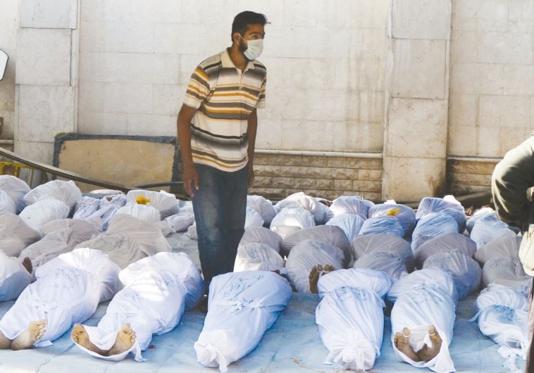 Syrian activists inspect the bodies of people they say were killed by nerve gas in the Ghouta region, in the Duma neighborhood of Damascus on August 21, 2013 / Reuters 