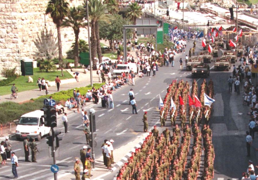 IDF humvees lead a column of paratroopers past the Old City walls into central Jerusalem during a Jerusalem Day parade in 1998 (photo credit: REUTERS)