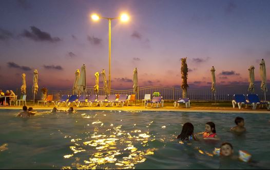 Palestinian children swim in a pool as they enjoy the warm weather with their families at the Blue Beach Resort in Gaza (credit: REUTERS)