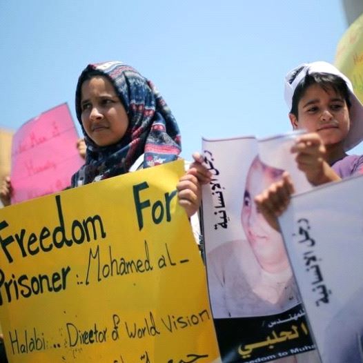 Palestinian demonstrators take part in a protest in solidarity with Mohammad El Halabi, World Vision's manager of operations in Gaza who was accused by Israel of funnelling millions of dollars in aid money to Hamas, organised by foundations and societies benefiting from World Vision in Gaza City Aug (credit: REUTERS)
