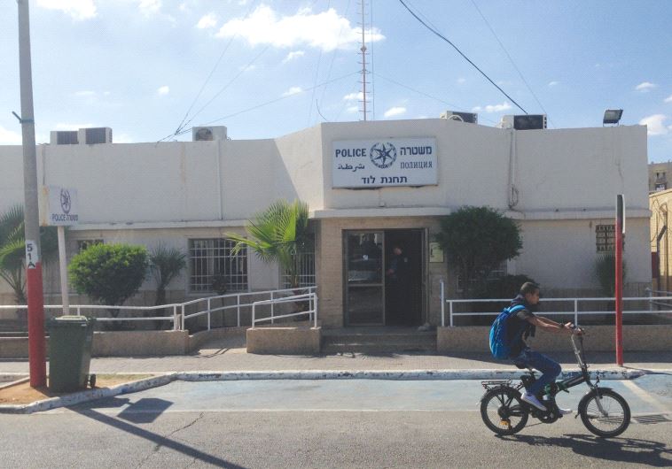 AN OFFICER stands in the doorway of the Israel Police station in Lod. (credit: ELIYAHU KAMISHER)