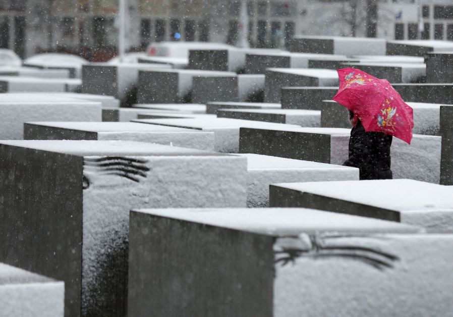 A woman walks through the Holocaust memorial during heavy snowfall in Berlin. (credit: REUTERS)