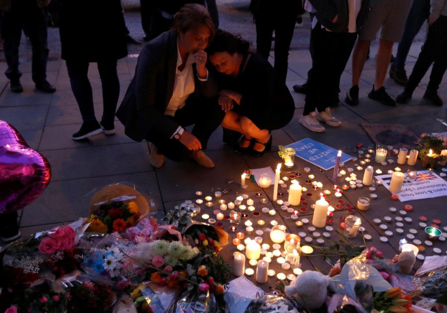 People pay their respects to the victims of the deadly suicide bombing in Manchester that took place during an Ariana Grande concert.  (credit: REUTERS)