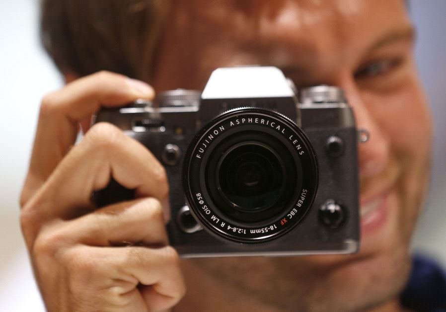 A model poses with a camera (credit: REUTERS/INA FASSBENDER)