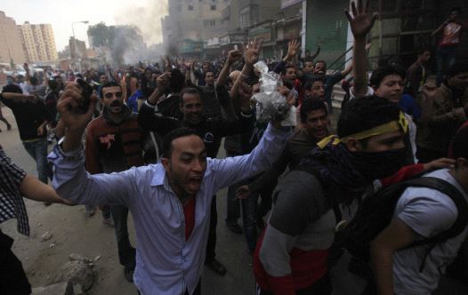 Supporters of the Muslim Brotherhood and ousted Egyptian President Mohamed Mursi shout slogans in front of riot police and army and their supporters, during clashes at El-Talbyia near Giza square, south of Cairo, November 29, 2013 (credit: REUTERS)