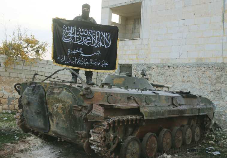 A member of al-Qaida’s Nusra Front fighting with other Sunni Islamists in support of the Syrian opposition pose on a tank near Aleppo in November 2014.