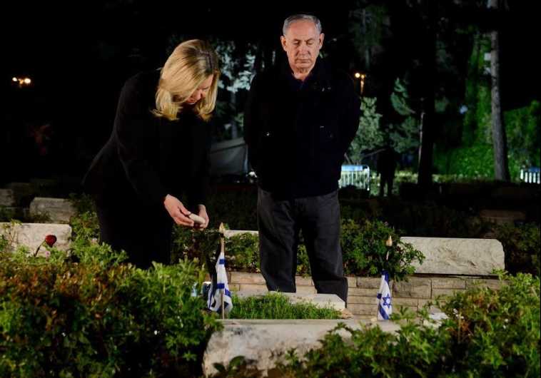 Prime Minister Benjamin Netanyahu (R) and his wife, Sara, pay respects to the premier's late brother, Yoni Netanyahu, who was killed during the Entebbe raid