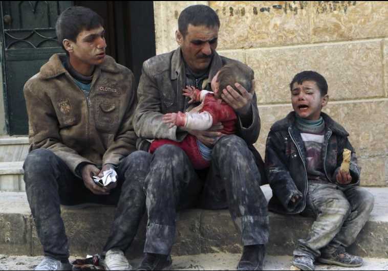 A man holds a baby saved from under rubble, who survived what activists say was an airstrike by forces loyal to Syrian President Bashar Assad in Aleppo