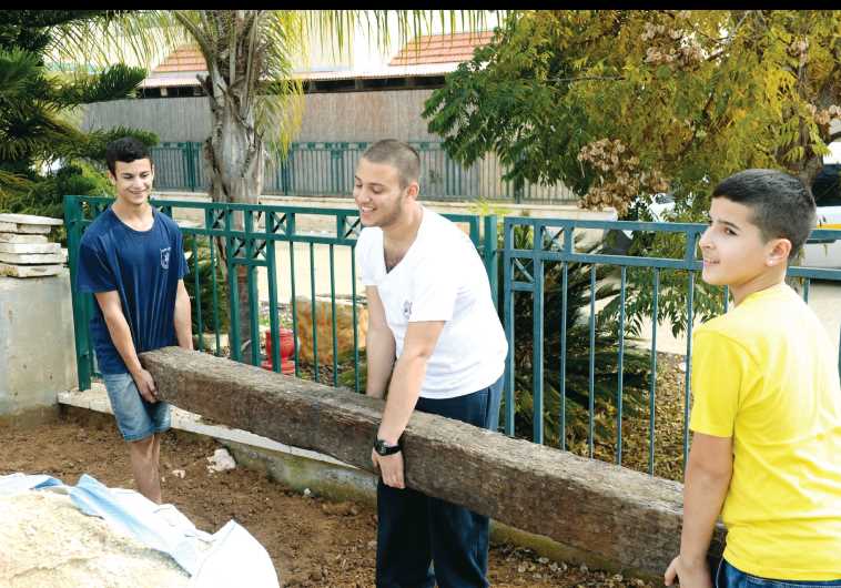 (From left to right) Sagi Farhi, Lidor Fachima and Iddo Ben-David help the Bayhesain family fix up their garden.