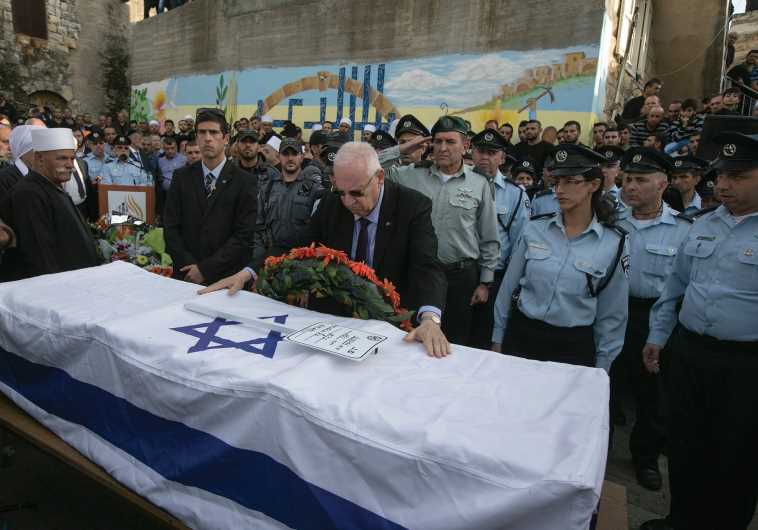 PRESIDENT REUVEN Rivlin touches the flag draped coffin of Israeli Druze police officer Zidan Nahad