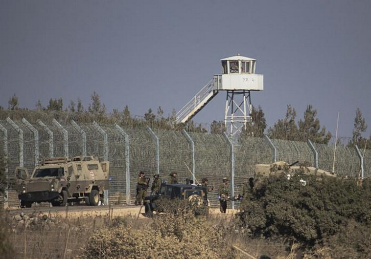 Israeli soldiers stand near the border with Syria in the Golan Heights