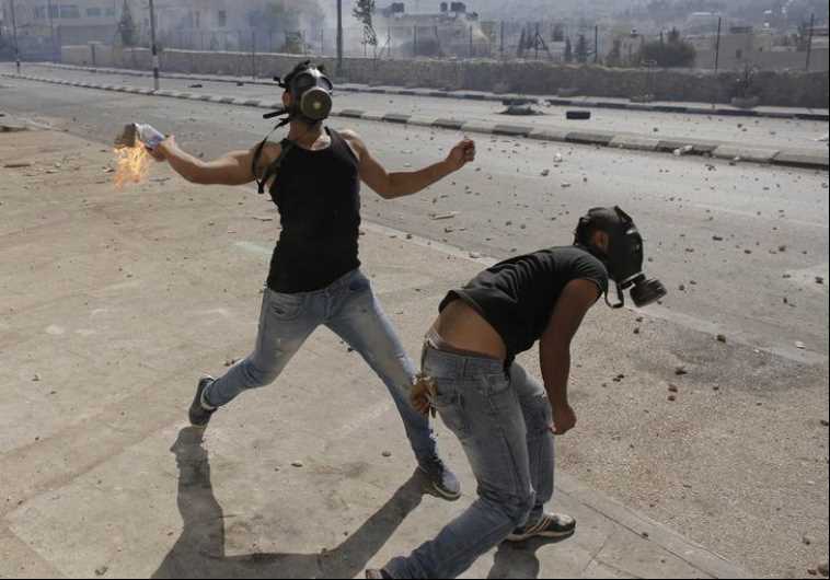 A Palestinian protester hurls a Molotov cocktail at Israeli troops following a demonstration against the Israeli offensive in Gaza, in the West Bank town of Bethlehem.