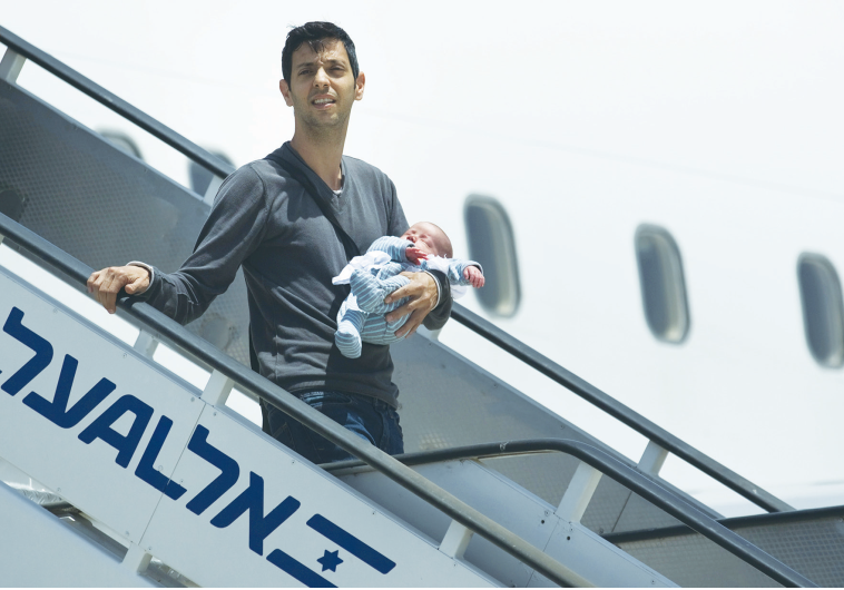 AN ISRAELI holds his surrogate-born baby as he disembarks yesterday from a plane at Ben-Gurion Airport after being evacuated from Nepal.