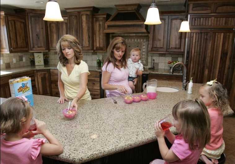 Sister-wives Valerie (L) and Vicki serve breakfast to their children in their polygamous house in Herriman, Utah