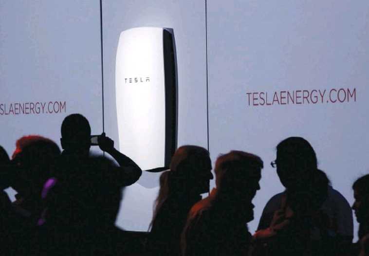 ATTENDEES TAKE pictures of the new Tesla Energy Powerwall Home Battery during an event at Tesla Motors in Hawthorne, California, last Thursday.
