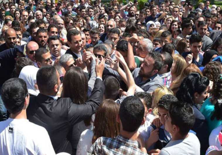 Syria's Assad with supporters at rare public appearance.‏