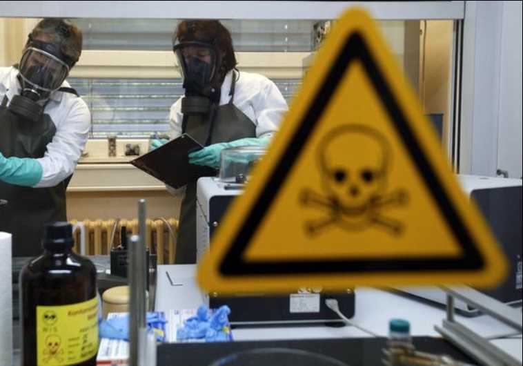 Employees of the Research Institute for Protective Technologies, Nuclear, Biological and Chemical Protection (WIS) inspect a dummy sample which is contaminated with a substance similar to the chemical weapon Sarin.