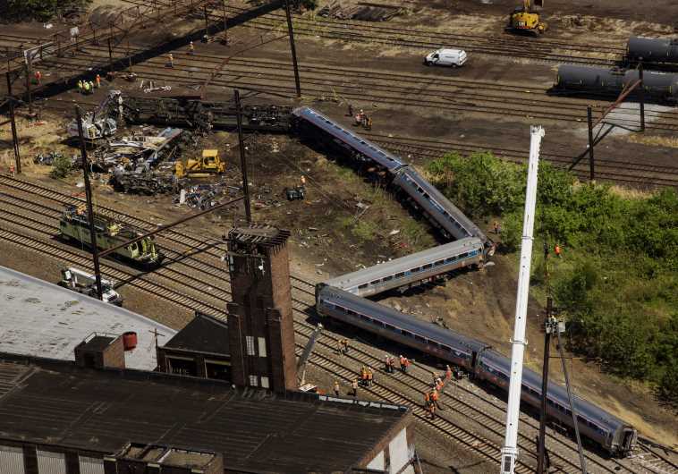 Emergency workers and Amtrak personnel inspect a derailed Amtrak train in Philadelphia, Pennsylvania 