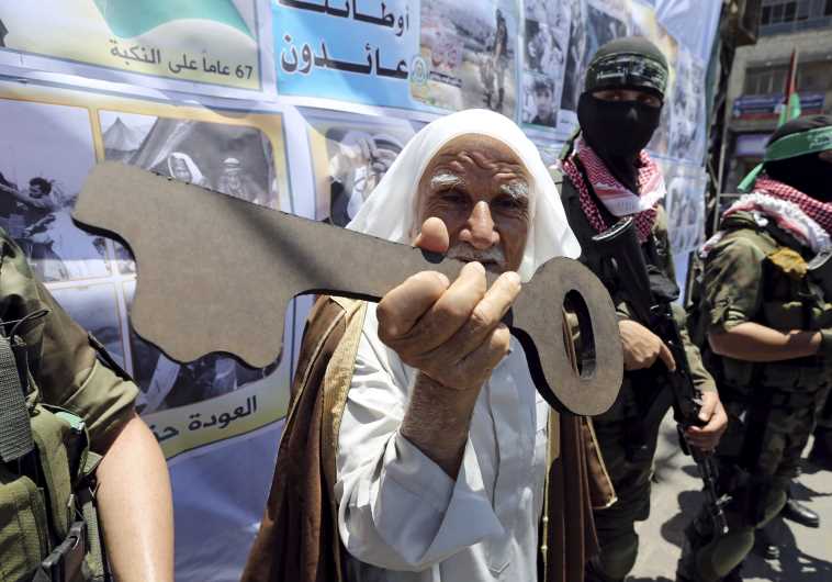 A Palestinian man holds a symbolic key next to Hamas militants during a rally after Nakba Day in Rafah