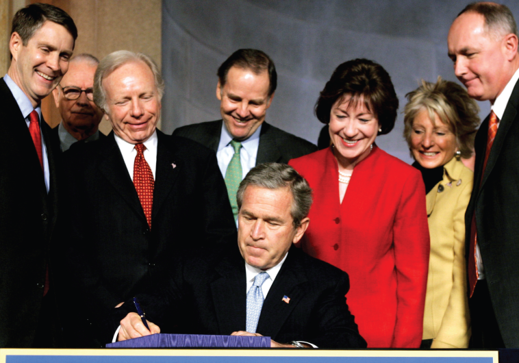 FORMER PRESIDENT George W. Bush signs the Intelligence Reform and Terrorism Prevention Act of 2004 in Washington