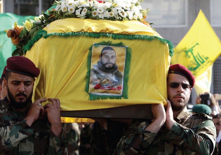 HEZBOLLAH MEMBERS carry the coffin of Adnan Siblini on Tuesday, who was killed in the Qalamoun region, during his funeral in al-Ghaziyeh.