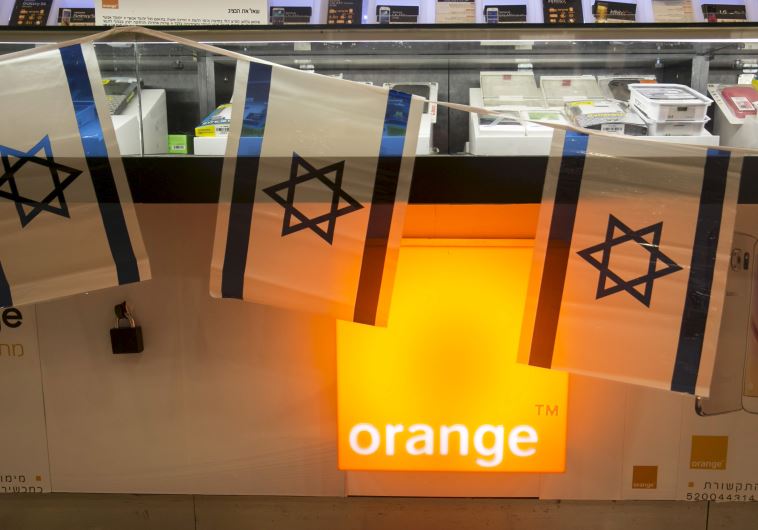 Israeli flags hang over the counter for the Orange mobile company at a mall in Tel Aviv