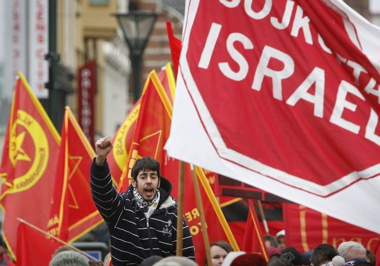 A protester chants slogans near a banner reading "Boycott Israel" during an anti-Israel march in Malmo