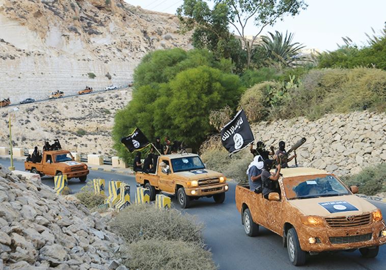An armed motorcade belonging to members of Derna’s Islamic Youth Council drives along a road in the town of Derna in eastern Libya on October 3, 2014, a day after the group pledged allegiance to the Islamic State.