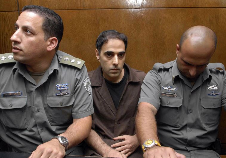 Israeli prison guards sit beside Yigal Amir (C), the assassin of Yitzhak Rabin, during a hearing in Tel Aviv district court, November 1, 2007