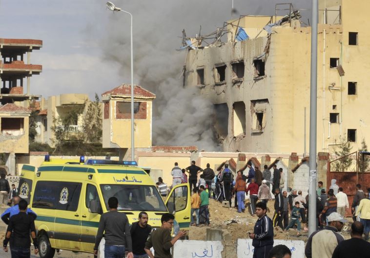 Egyptian residents and emergency personnel gather at the site of a car bomb explosion that targeted a police station in North Sinai's provincial capital of El-Arish on April 12, 2015. 