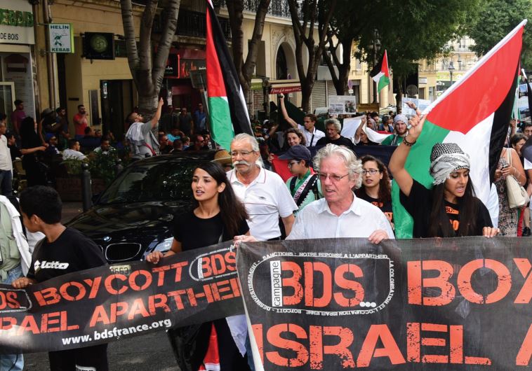Anti-Israel demonstrators march behind a banner of the BDS organization in Marseille, June 13.