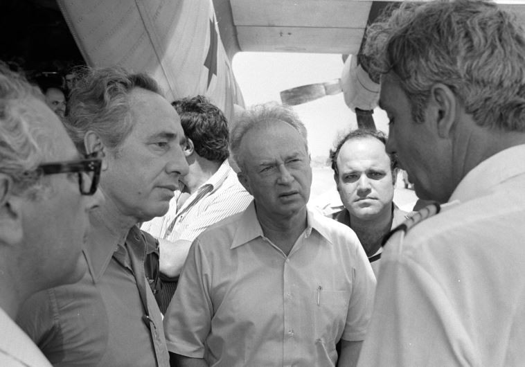 Then-prime minister Yitzhak Rabin (C) and then-defense minister Shimon Peres (2nd L) greet hostages rescued from Entebbe back in Israel