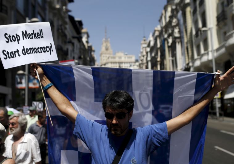 A man holds up a Greek national flag during a demonstration in support of Greece