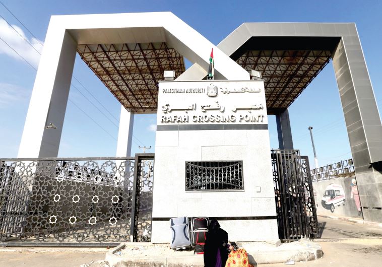 A Gaza woman waits at Rafah for a travel permit to cross into Egypt, June 14.