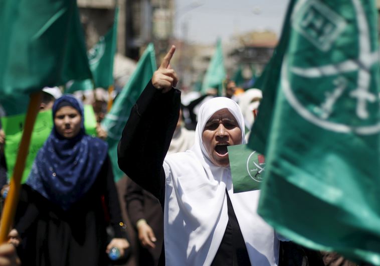 Protesters from the Islamic Action Front wave their party flags and shout slogans during a protest in support of Palestinians
