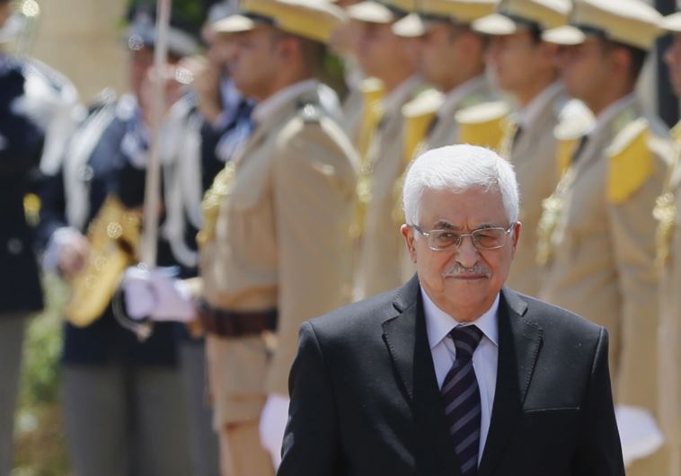 Palestinian President Mahmoud Abbas walks with Italy's Prime Minister Matteo Renzi (unseen) as they review the honor guard in the West Bank city of Bethlehem