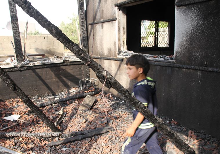 One of the boys from the family in Duma walks among the ruins