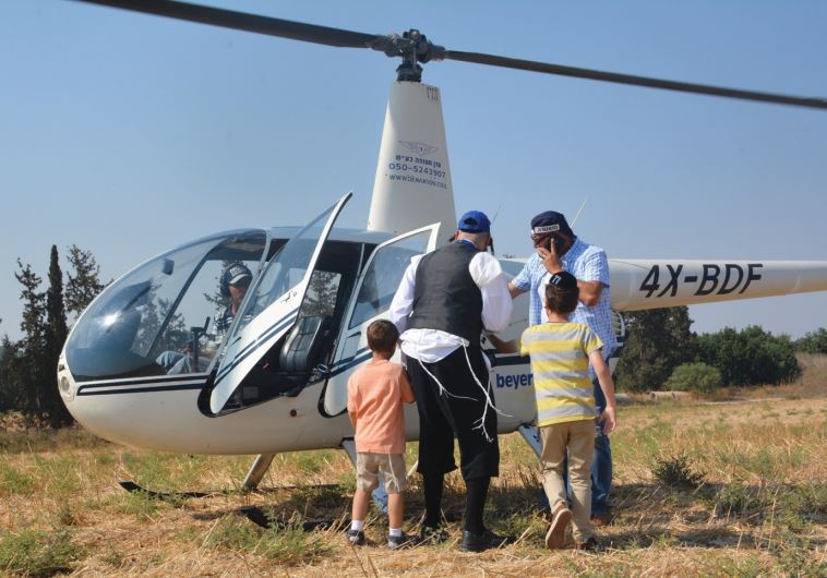 MOTTI FRIED (center) helps children from his organization Saad V’Marpe get into a helicopter for a ride as part of a recent week-long summer camp.